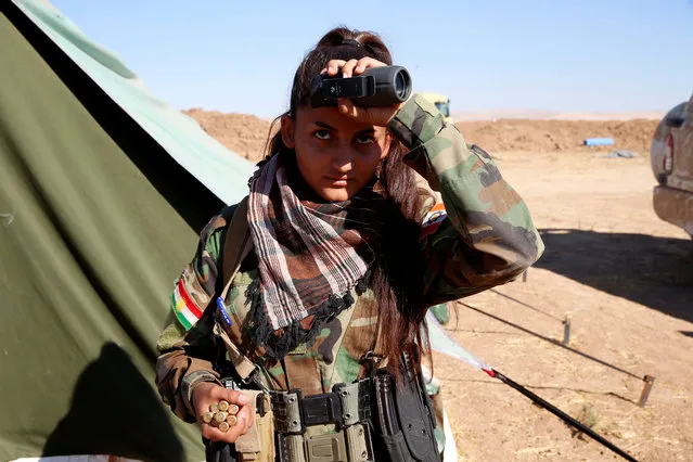 An Iranian-Kurdish female fighter carries bullets during a battle with Islamic State militants in Bashiqa, near Mosul, Iraq on November 3, 2016. (Photo by Ahmed Jadallah/Reuters)