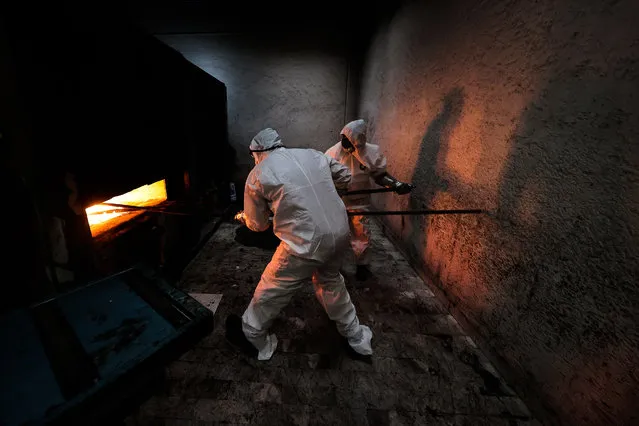 Crematorium workers enter the body of a person who died from COVID-19 into the oven to be cremated at the San Isidro Crematorium in Azcapotzalco on July 15, 2020 in Mexico City, Mexico. The crematorium is receiving 20 corpses a day, when before the pandemic received an average of five. Mexican Health Secretary announced the country has over 36,000 victims from COVID-19, surpassing Italy but behind US, Brazil and UK. According to Johns Hopkins University, Mexico has registered 311,486 positive cases. Critics say Government started reopening economy too soon and this would increase number of victims. At the beginning of the pandemic, President Lopez Obrador had been accused of downplaying the effects of the virus to protect economic activity. (Photo by Hector Vivas/Getty Images)