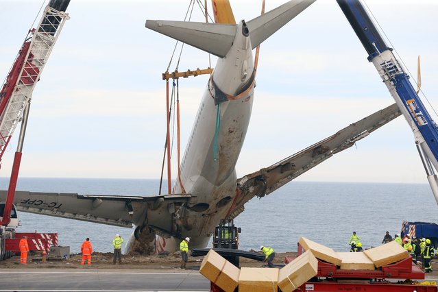 Cranes lift Pegasus airplane which was stucked in mud as it skidded off the runway after landing in Trabzon Airport, Turkey on January 18, 2018. (Photo by Hakan Burak Altunoz/Anadolu Agency/Getty Images)
