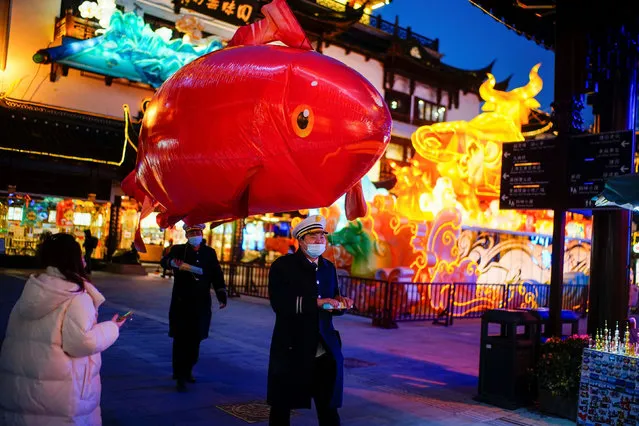 Security guards wearing face masks carry a giant balloon in the shape of a fish ahead of the Chinese Lunar New Year festivity at Yu Garden, following the coronavirus disease (COVID-19) outbreak in Shanghai, China on January 29, 2021. (Photo by Aly Song/Reuters)