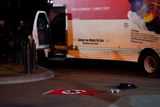 A Nazi flag and other objects recovered from a rented box truck are pictured on the ground as the U.S. Secret Service and other law enforcement agencies investigate the truck that crashed into security barriers at Lafayette Park across from the White House in Washington, U.S. May 23, 2023. (Photo by Nathan Howard/Reuters)