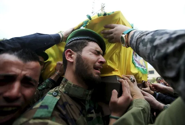 A Lebanon's Hezbollah member reacts as he carries with others the coffin of his comrade, Mohamad Sfawi, who was killed fighting alongside Syrian army forces in Syria, during his funeral in Qnarit village, southern Lebanon, December 13, 2015. (Photo by Ali Hashisho/Reuters)