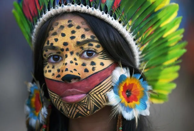 A woman from the Pataxo tribe poses for a photo at an indigenous protest camp on the fourth day of the Terra Livre Indigenous Camp in Brasilia on April 7, 2022. The 10-day annual protest is held by indigenous people from tribes that arrive from all over Brazil, and calls for greater protection of their land and rights. (Photo by Carl de Souza/AFP Photo)