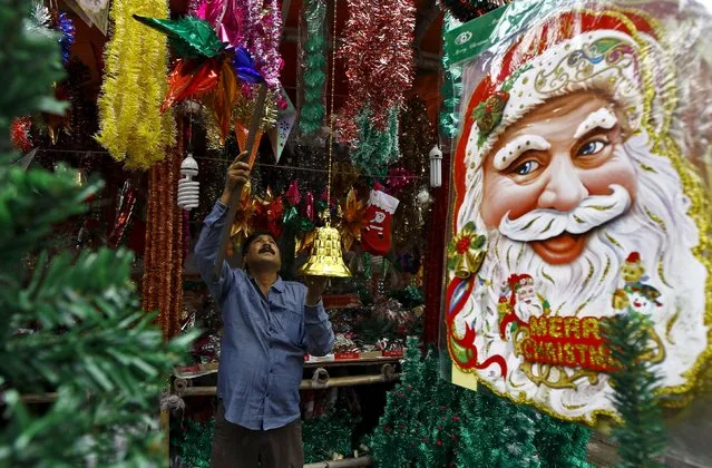 A vendor hangs decorative items for sale at his roadside stall ahead of Christmas in Kolkata, India, December 18, 2015. (Photo by Rupak De Chowdhuri/Reuters)