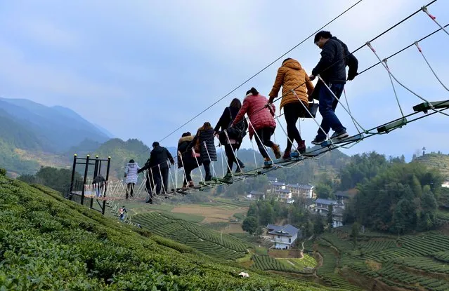 Tourists walk above a tea plantation in Enshi, Hubei province, December 27, 2015. (Photo by Reuters/Stringer)