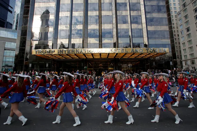 A performance group walks past the Trump International Hotel and Tower during the 90th Macy's Thanksgiving Day Parade in Manhattan, New York, U.S., November 24, 2016. (Photo by Andrew Kelly/Reuters)