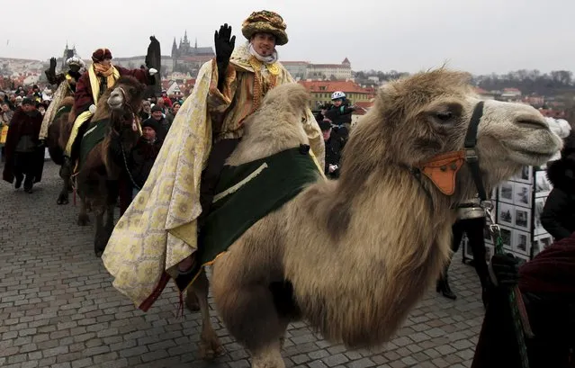 Men dressed as the Three Kings greet spectators as they ride camels during the Three Kings procession across the medieval Charles bridge, as part of a re-enactment of the Nativity scene, in Prague, Czech Republic, January 3, 2016. (Photo by David W. Cerny/Reuters)