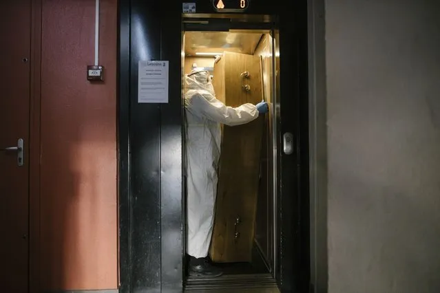 In this image released by World Press Photo, Thursday April 15, 2021, by Laurence Geai, part of a series titled Pandemic in France, which won the third prize in the General News Stories category, shows A morgue employee transports a coffin from the fifth floor of an apartment block, in the Parisian suburb of Pantin, on April 23, 2020. (Photo by Laurence Geai, World Press Photo via AP Photo)