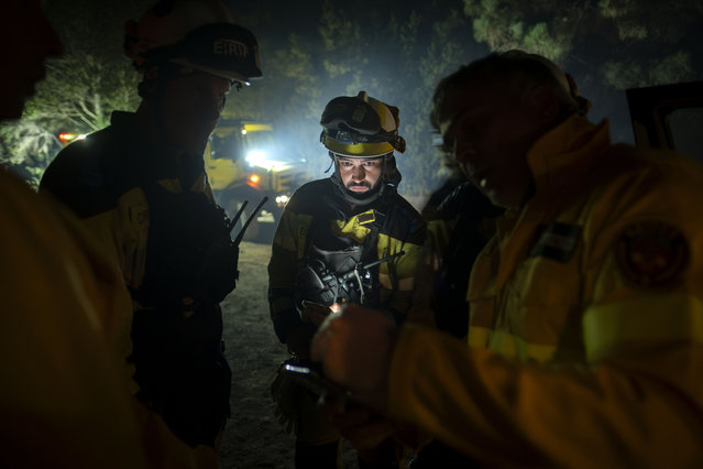 Emergency crews and firefighters work near the fire advancing through the forest toward the town of El Rosario in Tenerife, Canary Islands, Spain on Friday, August 18, 2023. Officials say a wildfire is burning out of control through the Spanish Canary Island of Tenerife, affecting nearly 8,000 people who have been evacuated or ordered to stay indoors. (Photo by Arturo Rodriguez/AP Photo)