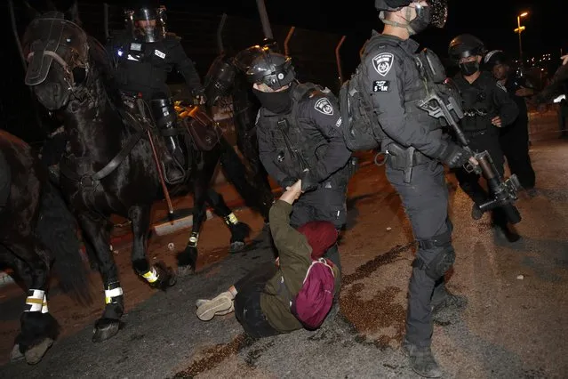 Israeli police officers detain a Palestinian demonstrator during a protest against the planned evictions of Palestinian families in the Sheikh Jarrah neighborhood of east Jerusalem, Saturday, May 8, 2021. (Photo by Oded Balilty/AP Photo)