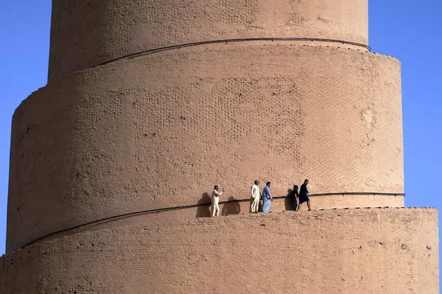 Iraqis visit the spiral Malwiya minaret, a mid-ninth century treasured Iraqi national monument, within the Samarra Archaeological City, in Samarra, north of Baghdad, on July 26, 2022. The 50m helicoidally tower of sun-dried and baked brick, modelled on ancient ziggurats that was built to symbolise the power of Islam during the Abbasid caliphate, was listed UNESCO World Heritage Site in 2007. (Photo by Ismael Adnan/AFP Photo)