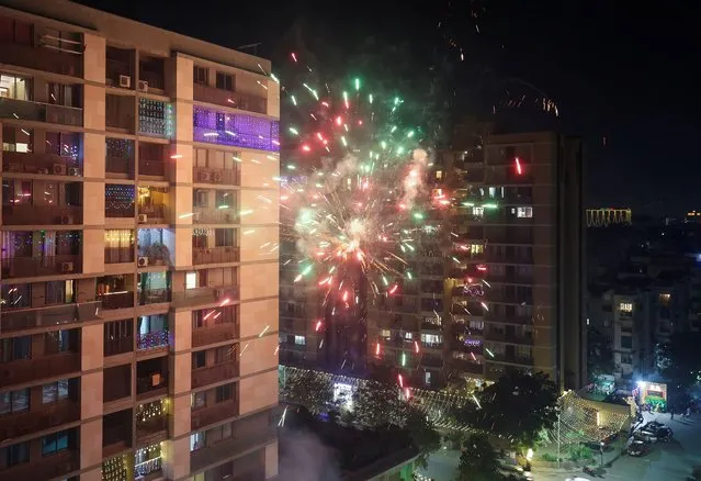 Fireworks explode in front of a residential building to celebrate Diwali, the Hindu festival of lights, in Ahmedabad, India on November 12, 2023. (Photo by Amit Dave/Reuters)