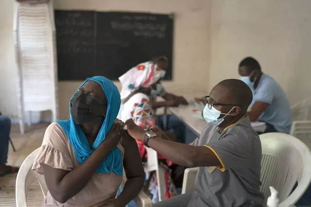 A health worker administers a dose of Janssen Johnson & Johnson COVID-19 vaccine at Dakar's Medina neighborhood, Senegal, Wednesday, July 28, 2021. In the midst of a third wave of the coronavirus pandemic, with many countries on the cusp, African health officials are racing to vaccinate populations that had before been reluctant or unable to access vaccines. (Photo by Leo Correa/AP Photo)