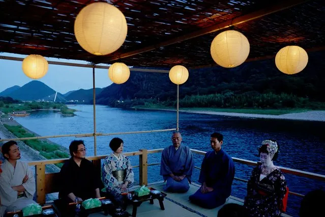 Houkan (male counterpart to Geisha) Tatsuji, 29, and Maiko (apprentice female Geisha), Kikuyu, 20, sit with visitors to watch cormorant fishing or ukai, at a riverside observation deck in the Nagara River, during a trial organized by the nonprofit organization ORGAN in Gifu, Japan on September 13, 2023. Ukai, or cormorant fishing, is a 1,300-old tradition largely supported by tourists nowadays, with fleets of boats allowing visitors to eat and drink as they watch the fishermen and birds downriver from Oze. “We wanted to offer a more refined, higher-quality experience”, said ORGAN leader Yusuke Kaba. (Photo by Kim Kyung-Hoon/Reuters)