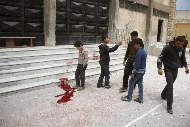 Residents inspect blood stains after what activists said was shelling by warplanes loyal to Syria's president Bashar Al-Assad on Saad Al-Ansari school in Aleppo's rebel-controlled Al-Mashad neighbourhood April 12, 2015. (Photo by Abdalrhman Ismail/Reuters)