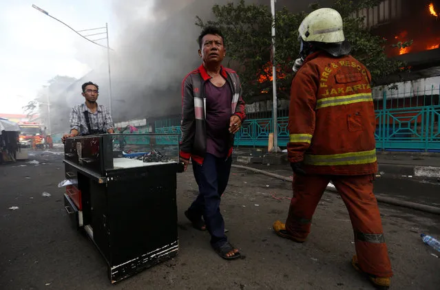 People move their belongings and goods during a large fire at Senen market in Jakarta, Indonesia January 19, 2017. (Photo by Darren Whiteside/Reuters)