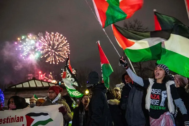 New Year's Eve fireworks go off in the sky as Pro-Palestinian supporters protest in Boston, Massachusetts on December 31, 2023. Israeli strikes pounded Gaza on December 31 as both sides near the end of a dark year and Prime Minister Benjamin Netanyahu warned the war sparked by Hamas's October 7 attack will last for “many months”. (Photo by Joseph Prezioso/AFP Photo)