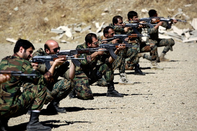 In this Thursday, September 19, 2013 photo, members of the Basij paramilitary militia fire their weapons during a training session, in Tehran, Iran. (Photo by Ebrahim Noroozi/AP Photo)