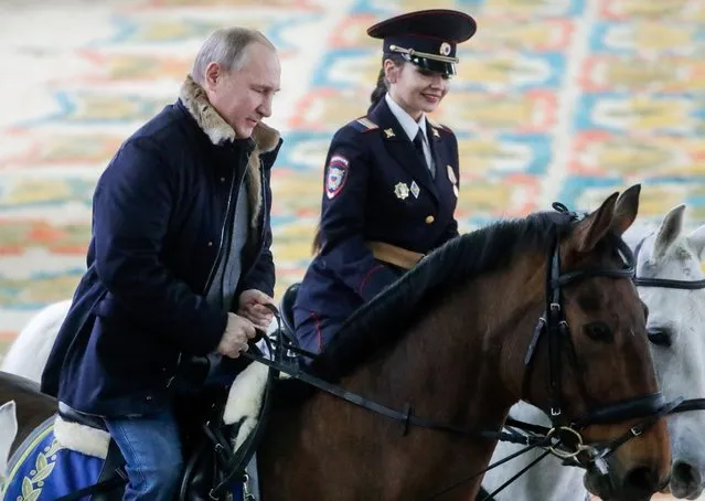 Russia's President Vladimir Putin (L) visits the 1st Operational Police Regiment under the Main Moscow Directorate of the Russian Interior Ministry in Moscow, Russia on March 7, 2019 ahead of International Women's Day annually celebrated on March 8. (Photo by Mikhail Metzel/TASS)