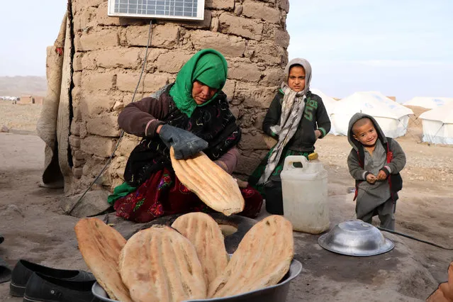 An Afghan Internally Displaced woman bake bread in mud oven outside her temporary shelter on the outskirts of Herat, Afghanistan, 17 January 2019. According to rights groups hundreds of thousands of Afghans have been forced to flee their homes due to violence in the past several years and urged the Afghan government and the international community to tackle the country's growing crisis of refugees internally displaced by war. (Photo by Jalil Rezayee/EPA/EFE)