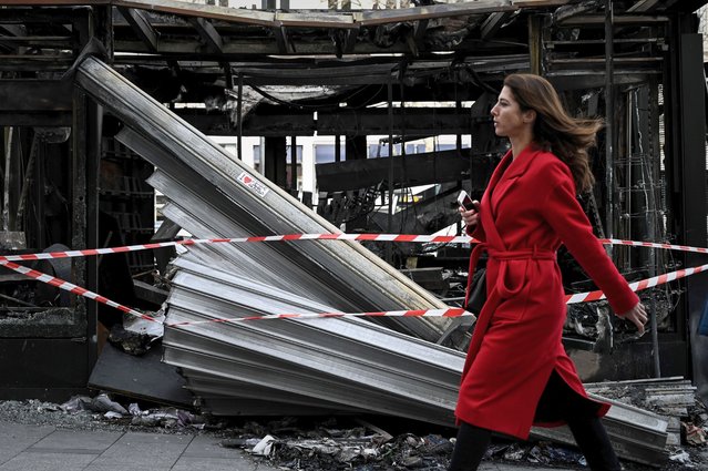 A woman walks past the wreckage of a newsstand in Paris on March 18, 2019 two days after it was damaged by protesters during clashes with riot police forces on the Champs-Elysees during the 18th consecutive Saturday of demonstrations called by the “Yellow Vest” (gilets jaunes) movement. The “Yellow Vests” protesters in France originally started as a protest about planned fuel hikes but has morphed into a mass protest against President's policies and top-down style of governing. (Photo by Philippe Lopez/AFP Photo)