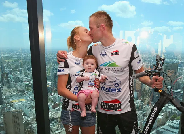 Krystian Herba, a Polish extreme cyclist is kissed by his wife Natalia Herba as she holds their daughter Emily after Krystian Herba jumped up the steps of Eureka Tower on a bicycle to break a Guinness World Record at Eureka Tower on February 4, 2014 in Melbourne, Australia. Herba jumped up 2,919 steps on his bicycle in 1 hour 45 minutes without supporting himself with his hands or feet to break his own Guinness World Record.  (Photo by Scott Barbour/Getty Images)