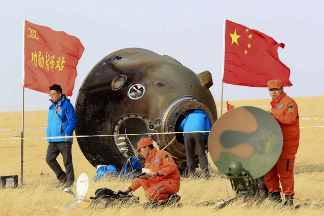 In this photo released by Xinhua News Agency, ground crew check on the re-entry capsule of Shenzhou 11 spacecraft after it landed in north China's Inner Mongolia Autonomous Region, Friday, November 18, 2016. A pair of Chinese astronauts returned Friday from a monthlong stay aboard the country's space station, China's sixth and longest crewed mission and a sign of the growing ambitions of its rapidly advancing space program. (Photo by Li Gang/Xinhua via AP Photo)