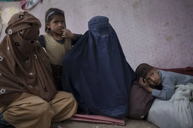 Malalai, center, from Kunduz province, sits with her children at a camp for internally displaced people as they wait for a bus to return home, in Kabul, Afghanistan, Saturday, October 9, 2021. (Photo by Felipe Dana/AP Photo)