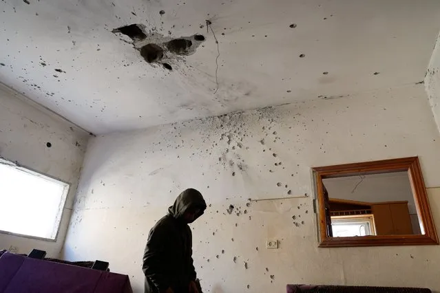 A person stands under a damaged ceiling, following an Israeli raid, in Jenin, in the Israeli-occupied West Bank on February 21, 2024. (Photo by Raneen Sawafta/Reuters)