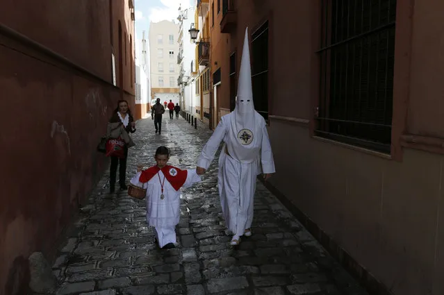 Members of San Gonzalo brotherhood make their way to the church to take part in a Holy Week procession in the Andalusian capital of Seville, southern Spain March 21, 2016. (Photo by Marcelo del Pozo/Reuters)