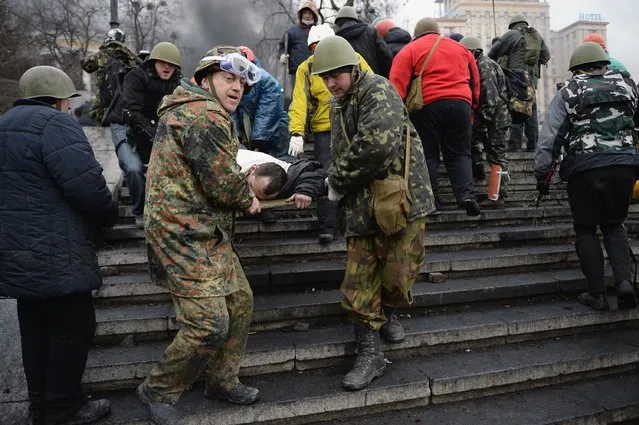 Anti-government protesters carry the injured during continued clashes with police in Independence square, despite a truce agreed between the Ukrainian president and opposition leaders on February 20, 2014 in Kiev, Ukraine. (Photo by Jeff J. Mitchell/Getty Images)