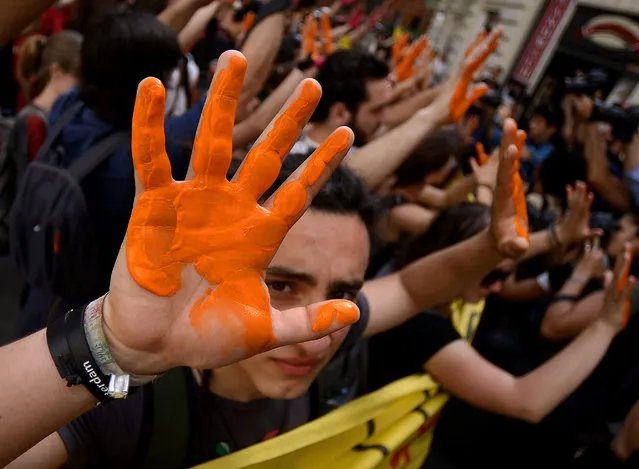 Students protest against Italian government's “Good School” reform bill with their hand coloured with paint in front of the Democratic Party (PD) on May 5, 2015 in Rome. (Photo by Filippo Monteforte/AFP Photo)