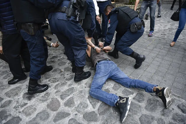 Police arrest a man who started shooting outside city hall in Cuernavaca, Mexico, Wednesday, May 8, 2019. A union official accompanying protesting street vendors and another trade unionist died during the shooting, while a TV cameraman and another person were wounded, according to officials  (Photo by Tony Rivera/AP Photo)