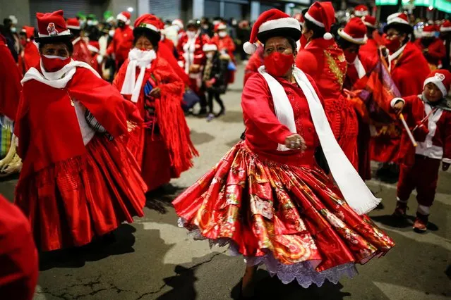Street market vendors participate in the annual Christmas parade, in La Paz, Bolivia on November 26, 2021. (Photo by Manuel Claure/Reuters)
