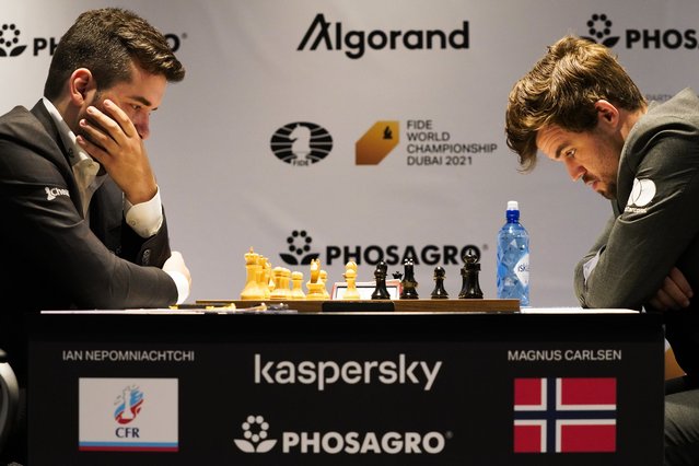 Ian Nepomniachtchi of Russia, left, and Magnus Carlsen of Norway, right, compete during the FIDE World Championship at Dubai Expo 2020 in Dubai, United Arab Emirates, Friday, December 10, 2021. (Photo by Jon Gambrell/AP Photo)