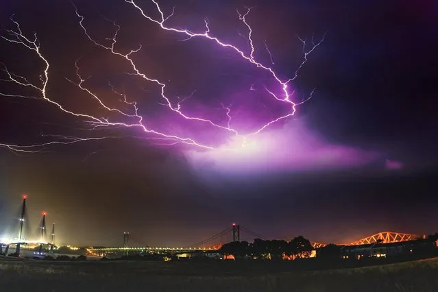 An amazing image of fork lightning above the three bridges over the Firth of Forth with the new Queensferry Crossing (left), The Forth Road Bridge (middle) and the Forth Rail Bridge (right). Sebastian Kuczynski from Edinburgh caught the strike while standing in South Queensferry at 1pm on July 26, 2018. (Photo by Sebastian Kuczynski/South West News Service)