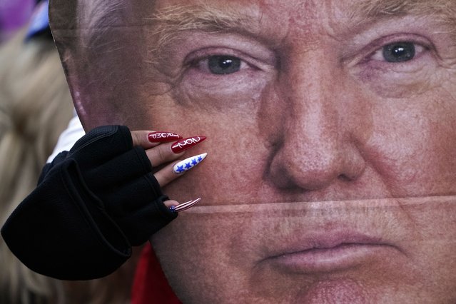 A woman holds a cutout of President Donald Trump's face at a rally in Washington in support of Trump called the “Save America Rally” on January 6, 2021. (Photo by Jacquelyn Martin/AP Photo)