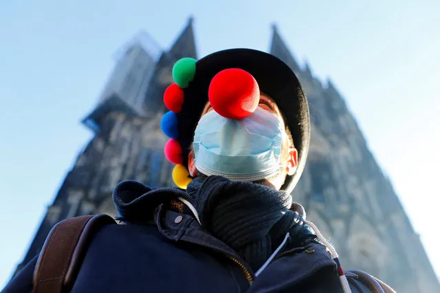 A lonesome reveller poses in front of Cologne Cathedral after carnival festivities were cancelled due to the coronavirus disease (COVID-19) pandemic in Cologne, Germany, February 11, 2021. (Photo by Thilo Schmuelgen/Reuters)