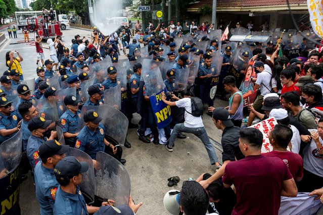 Police officers block Filipino activists from marching towards the U.S. Embassy during a Labor Day protest in Manila, Philippines on May 1, 2024. (Photo by Lisa Marie David/Reuters)