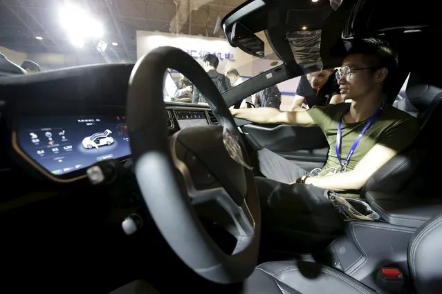 A visitor checks a Tesla Model S car during the Auto China 2016 in Beijing, China, April 25, 2016. (Photo by Jason Lee/Reuters)