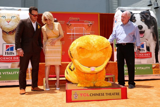 Cast members Hannah Waddingham and Chris Pratt, and Executive Producer Jim Davis, the creator of Garfield, react as a person wearing Garfield's costume places paw prints in cement during the world premiere of the film “The Garfield Movie” at TCL Chinese Theatre in Los Angeles, California, U.S., May 19, 2024. (Photo by Mario Anzuoni/Reuters)