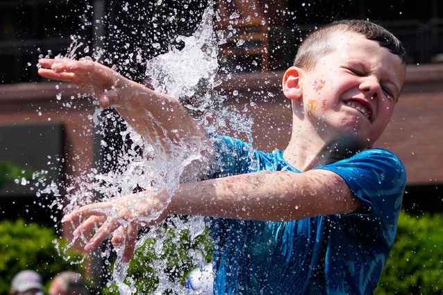 A boy cools off at a fountain outside Wrigley Field before a baseball game between the Chicago Cubs and St. Louis Cardinals as hot weather descends upon the Chicago area Sunday, June 16, 2024. (Photo by Nam Y. Huh/AP Photo)