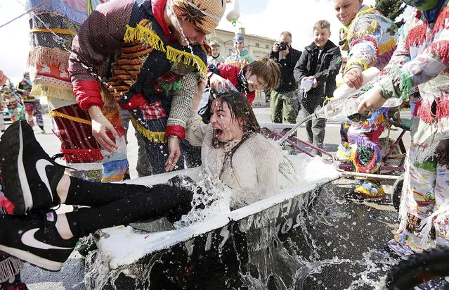 A girl is splashed with water by boys following a Polish Wet Easter Monday tradition, in Wilamowice, Poland, Monday, April. 17, 2017. (Photo by Jarek Praszkiewicz/AP Photo)