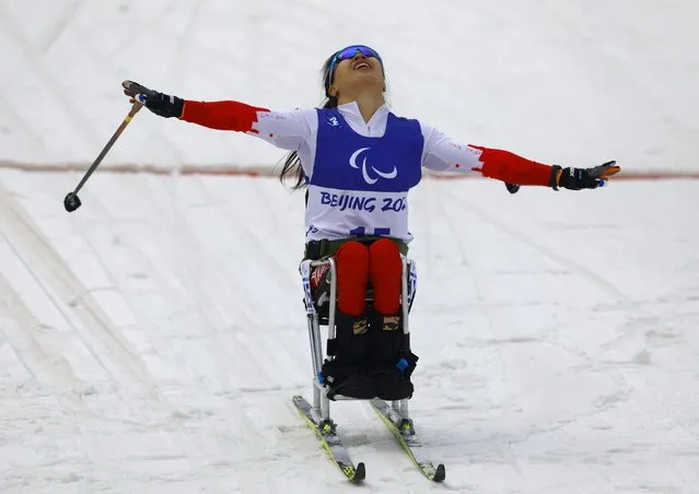Yang Hongqiong of Team China celebrates crossing the finish line to win the gold medal in Women's Sprint Sitting Final on day five of the Beijing 2022 Winter Paralympics at Zhangjiakou National Biathlon Centre on March 09, 2022 in Zhangjiakou, China. (Photo by Gonzalo Fuentes/Reuters)