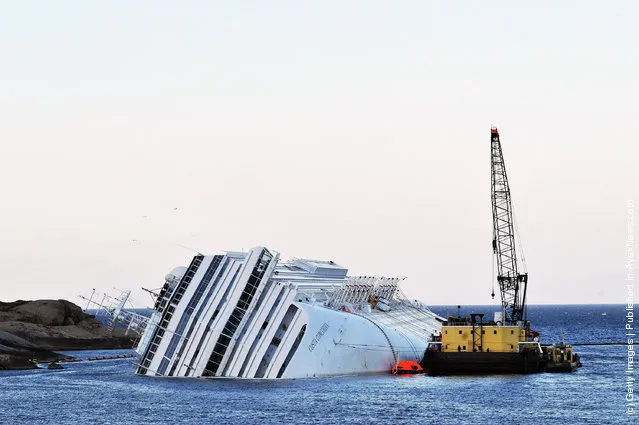 Rotterdam based SMIT and Livorno based NERI salvage workers start their work of diesel recovery on a pontoon from the the cruise ship Costa Concordia that lies stricken off the shore of the island of Giglio