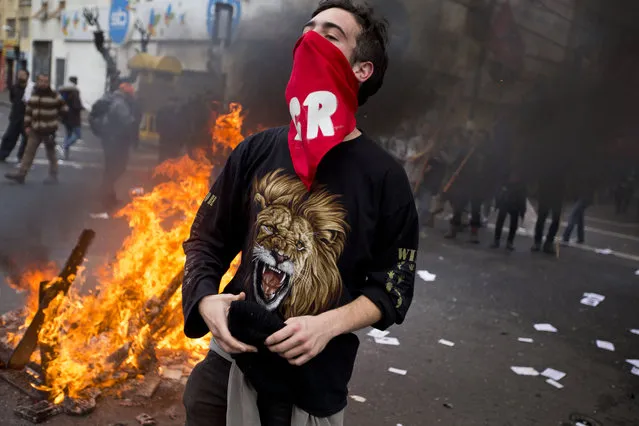 A masked man shout anti-government slogans against government on a street near Congress, where President Michelle Bachelet was presenting the state-of-the-nation report, in Valparaiso, Chile, Saturday, May 21, 2016. An anti-government protest that began as a peaceful march turned rough as some demonstrators threw rocks at police and gasoline bombs at buildings, resulting in the death of one man who reportedly died of asphyxiation. (Photo by Esteban Felix/AP Photo)