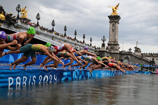 Athletes compete in the swimming race in the Seine during the women's individual triathlon at the Paris 2024 Olympic Games in central Paris on July 31, 2024. (Photo by Martin Bureau/AFP Photo)