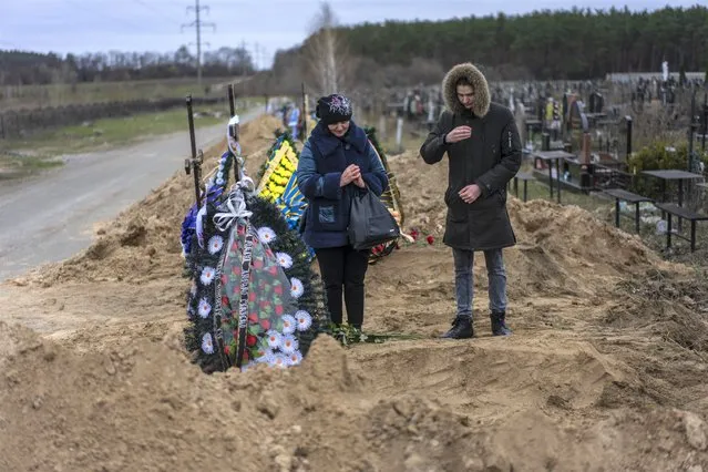 Natalya Verbova, 49, and her son Roman Verbovyi, 23, attend the funeral of her husband Andriy Verbovyi, 55, who was killed by Russian soldiers while in the territorial defense in Bucha on the outskirts of Kyiv, Ukraine, Wednesday, April 13, 2022. (Photo by Rodrigo Abd/AP Photo)