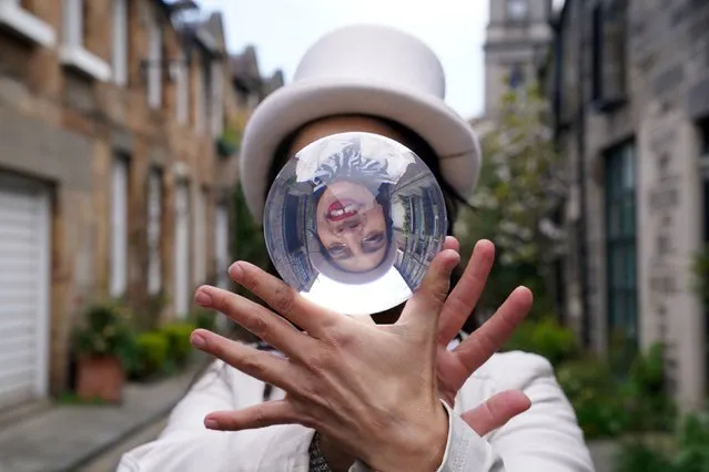 Jusztina Hermann with her crystal ball during a photocall in Circus Lane in Edinburgh on Friday, April 22, 2022, ahead of Cirqulation: Future, Scotlands Circus Cabaret Night at Assembly Roxy this weekend. (Photo by Andrew Milligan/PA Images via Getty Images)