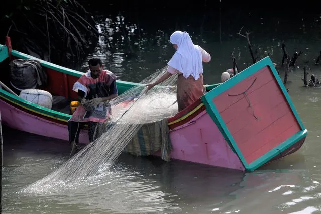 Fisherman pull fish from the net after fishing in the Syiah Kuala Beach area, in Banda Aceh, Indonesia, 20 April 2022. The Aceh government initiated a local sharia-based law known as the “Qanun” which regulates the use of coastal areas for the economic development of local communities through the fisheries sector and tourism. (Photo by Hotli Simanjuntak/EPA/EFE)